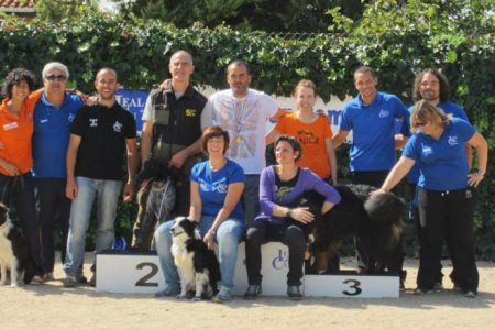 Grupo de 11 personas y 4 perros, en el podium despues de realizar la prueba de obediencia LealCan 2014.