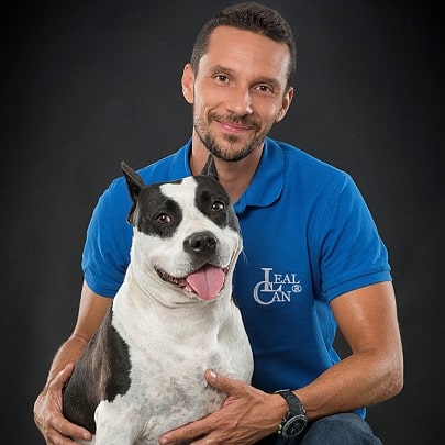 Foto del director y adiestrador canino Enrique Solís con un perro, ambos sonriendo.